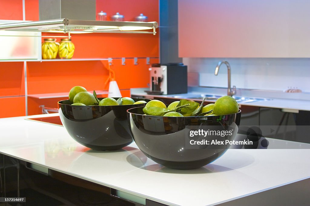 A luxury orange, white and black kitchen interior