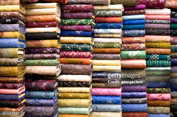 patterned textile fabrics on display - rolled up stockfoto's en -beelden