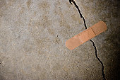 Crack in concrete with Band-Aid on top