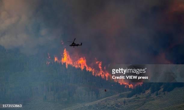 Smoke billows and flames rise from the Lowline fire on July 26, 2023 near Gunnison, Colorado. The US Forest Service said the fire was started by...
