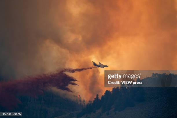 Plane drops retardant as smoke billows and flames rise from the Lowline fire on July 26, 2023 near Gunnison, Colorado. The US Forest Service said the...