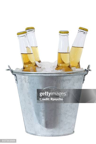 four beer bottles full and in a stainless bucket of ice - bucket stock pictures, royalty-free photos & images