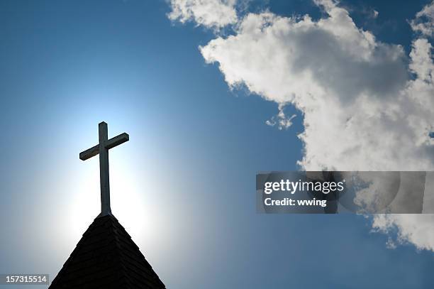 ostern morgen mit der sonne hinter einer kirche steepl cross. - kirchturmspitze stock-fotos und bilder