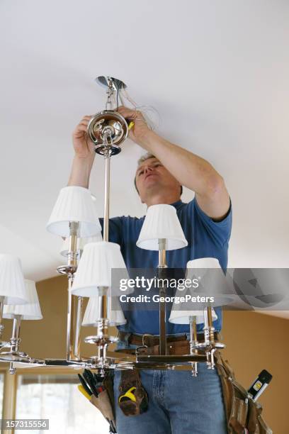 electrician installing designer chandelier - installing ceiling light fixture stock pictures, royalty-free photos & images