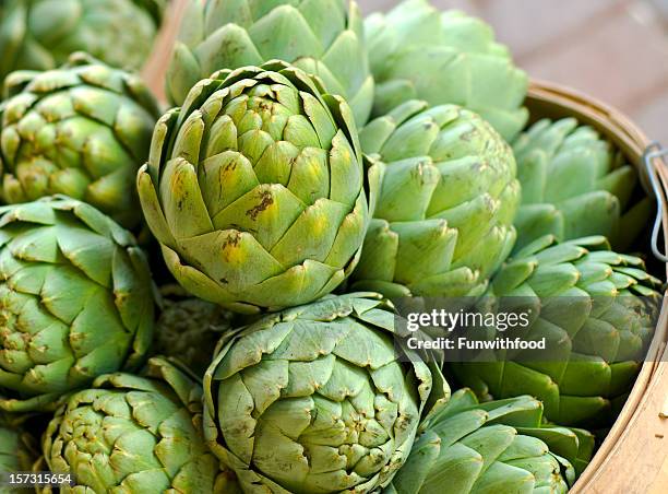 artichoke in baskets, fresh spring vegetables at farmer's market - artichoke stock pictures, royalty-free photos & images