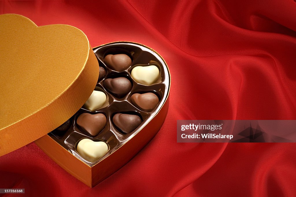 Golden chocolates box on red satin background