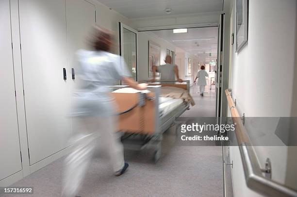 krankenschwestern ziehen ein krankenbett - station stock-fotos und bilder