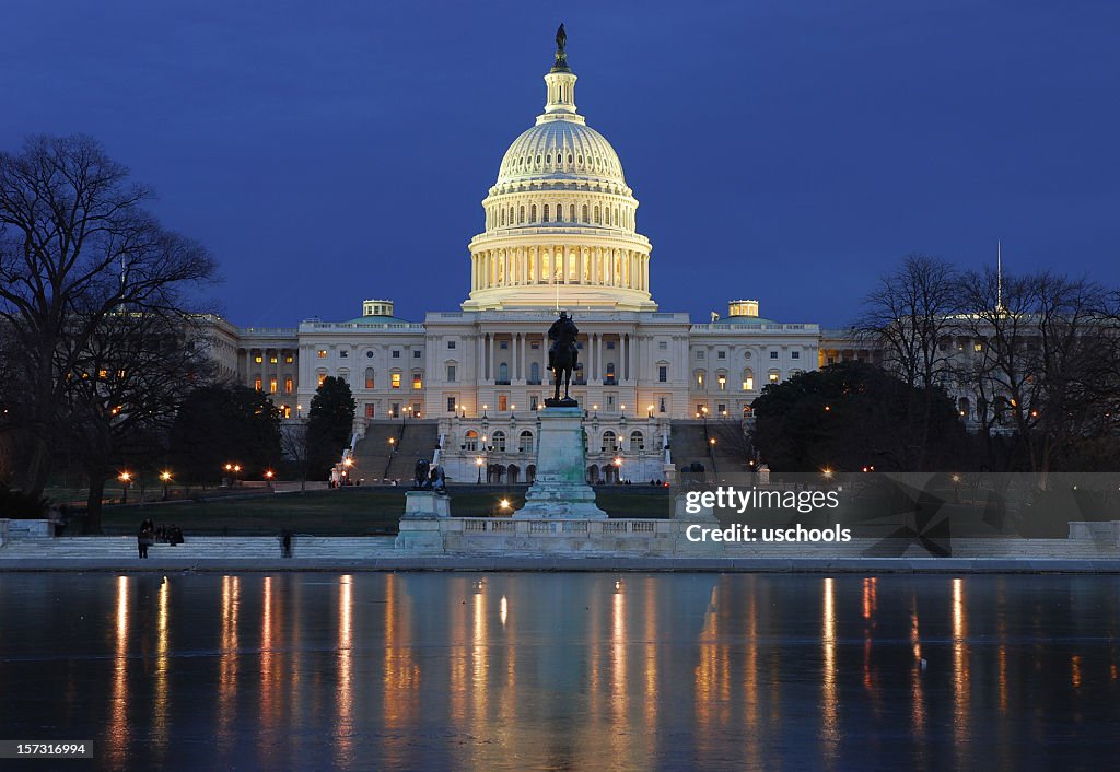 Illuminated US Capitol building with reflection on ice