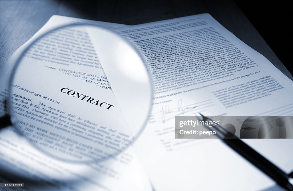 Magnifying Glass Examining Signed Legal Contract