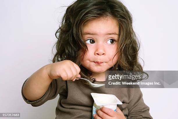 mädchen essen joghurt - children eating breakfast stock-fotos und bilder