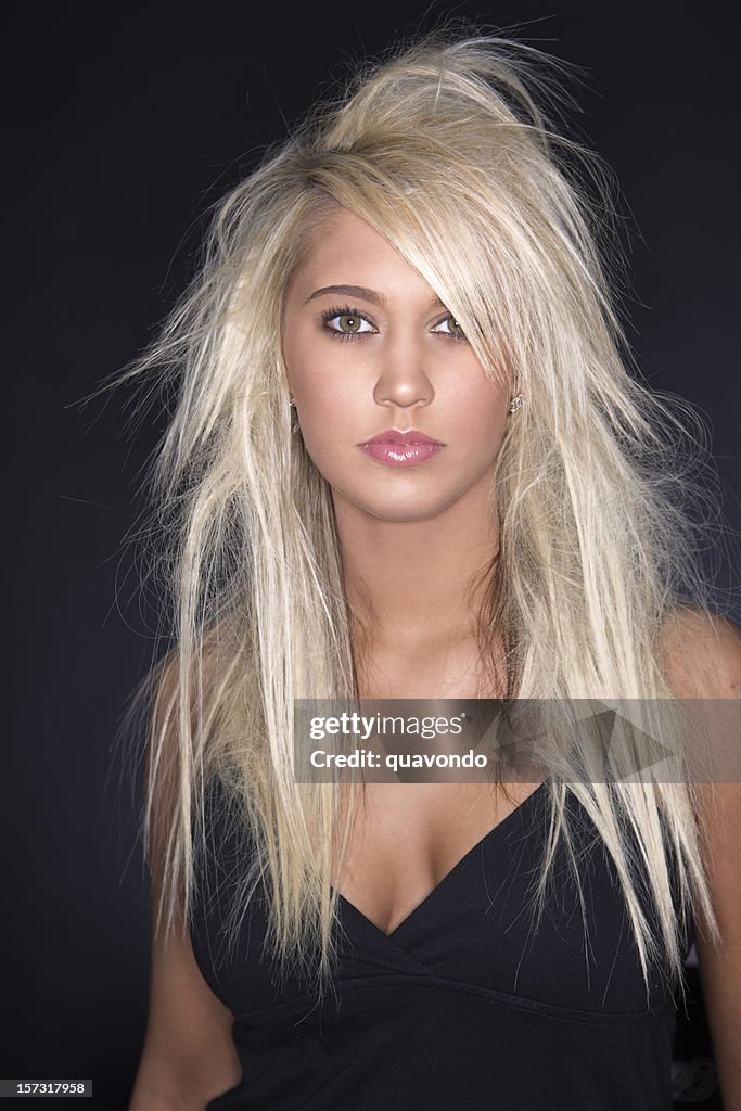 Hermosa joven mujer modelo con el pelo rubio extensiones sobre negro