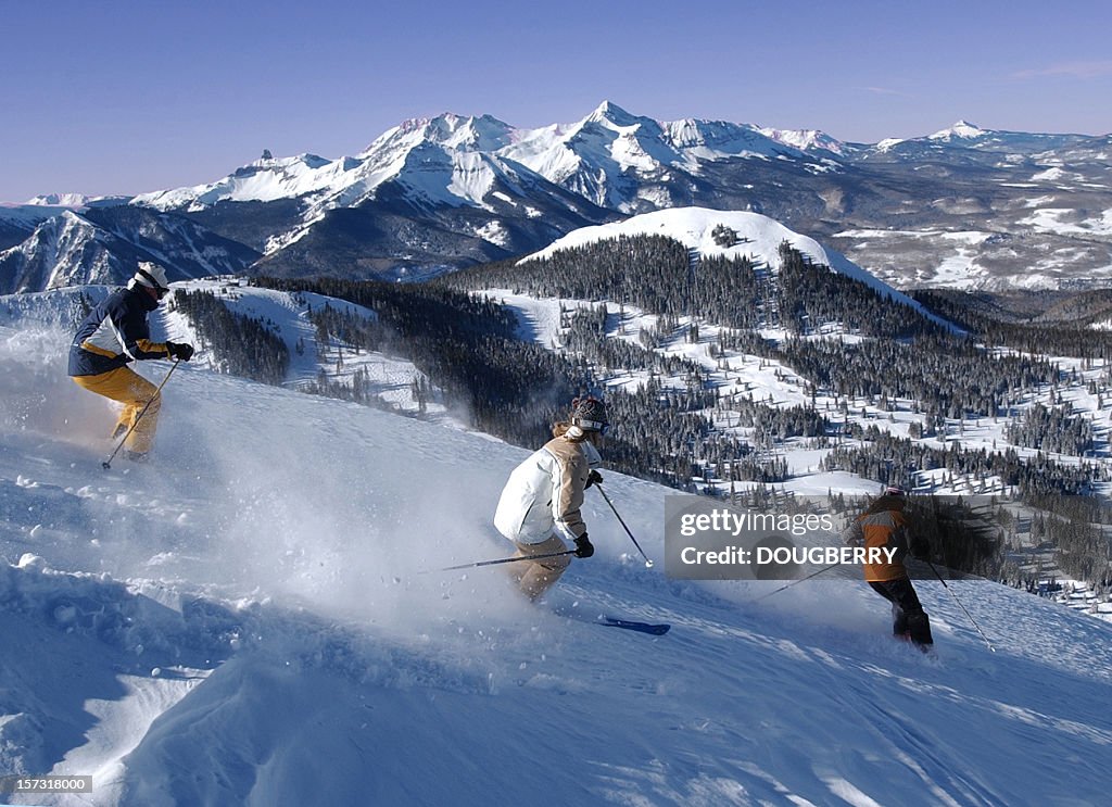 Three friends skiing fresh powder