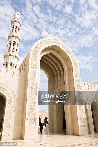 arches of sultan qaboos grand mosque in muscat - people from oman stockfoto's en -beelden