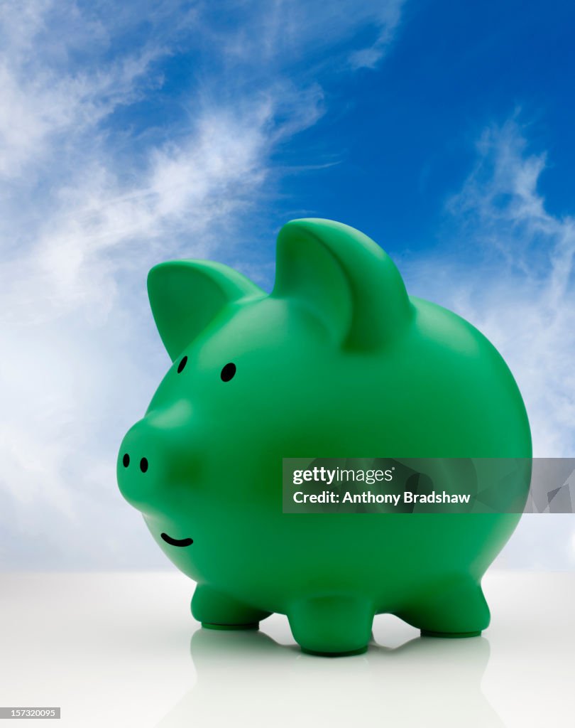 Green piggy bank against a blue sky