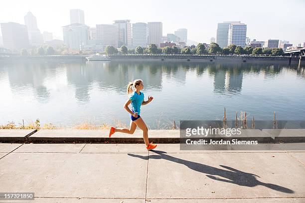 a young girl running for exercise. - girl side view stock-fotos und bilder