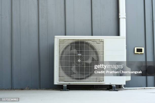 air conditioner (ac) or heating ventilation air conditioning system (hvac) beside house. - aire acondicionado fotografías e imágenes de stock
