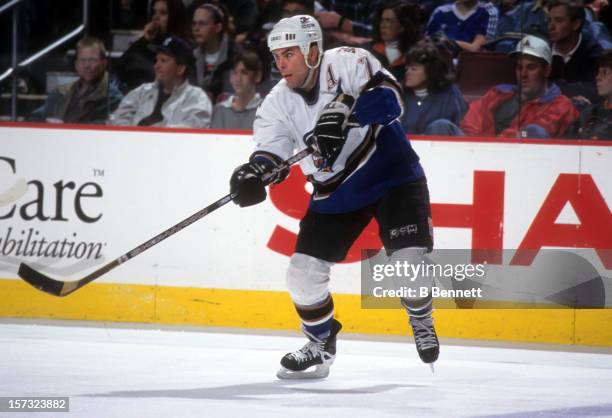 Adam Oates of the Washington Capitals passes the puck during an NHL game in April, 1998 at the Capital Centre in Landover, Maryland.