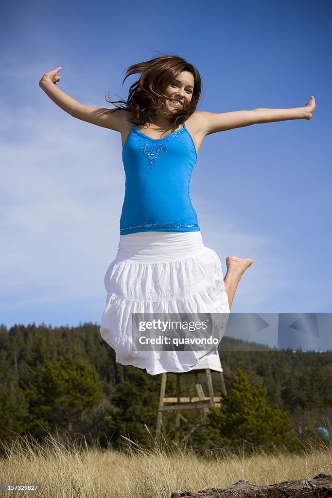 Beautiful Brunette Young Woman Jumping in Air Outside