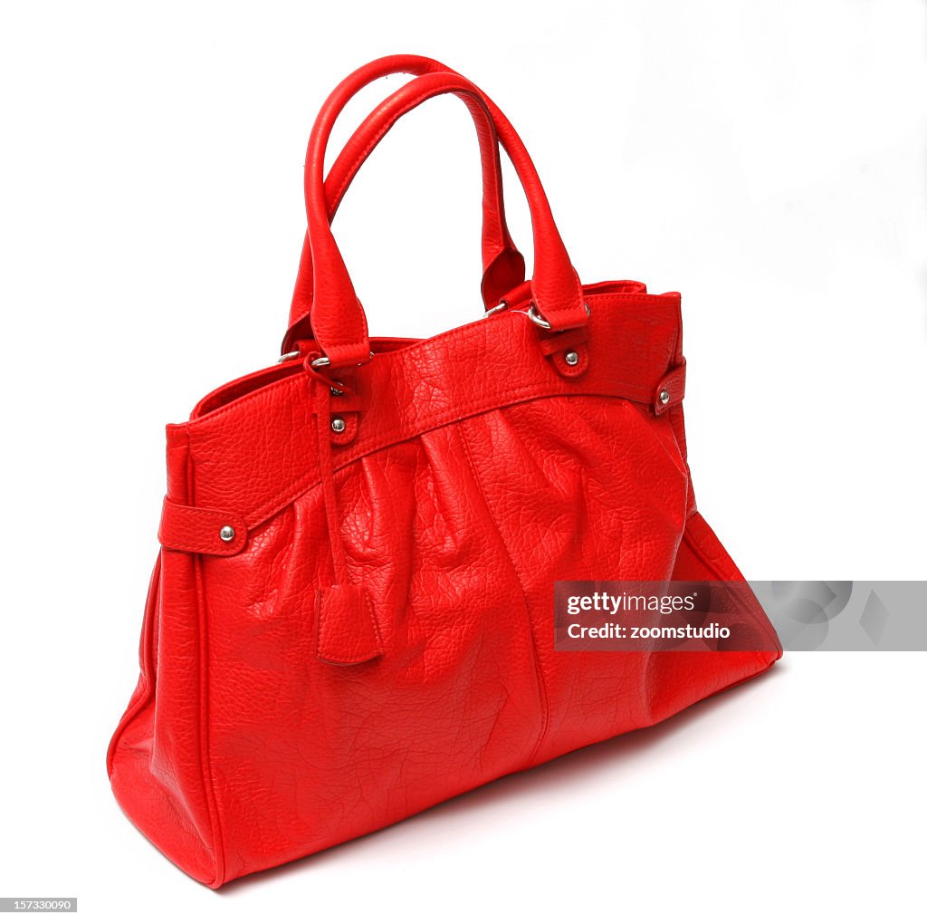 Close-up of red leather handbag in white background