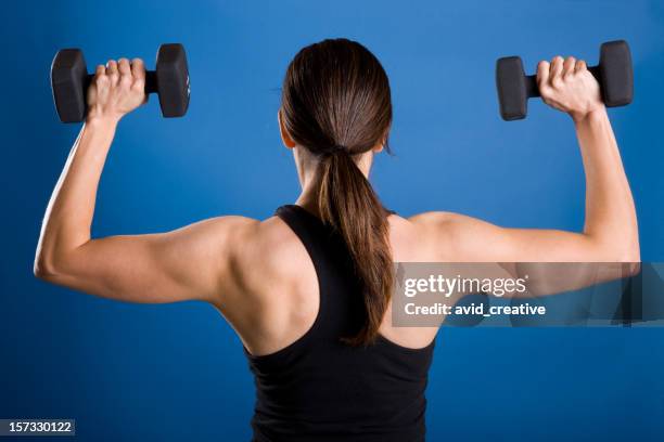 fitness-female lifting weights-rear view - dumbells isolated stock pictures, royalty-free photos & images