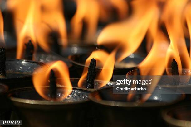 flames of tibetan oil lamps in a buddhist temple - soot stock pictures, royalty-free photos & images