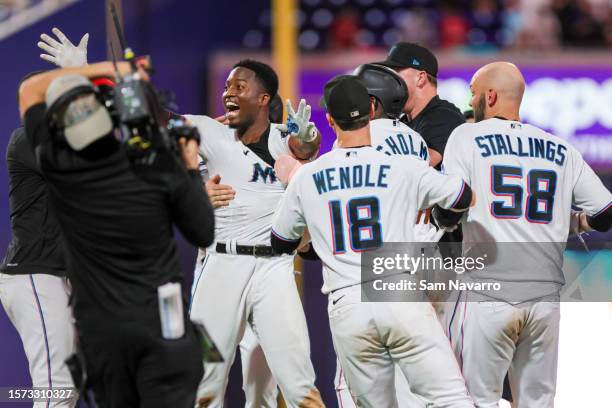 Jesus Sanchez of the Miami Marlins celebrates with teammates after hitting a walk-off single against the Philadelphia Phillies during the 12th inning...
