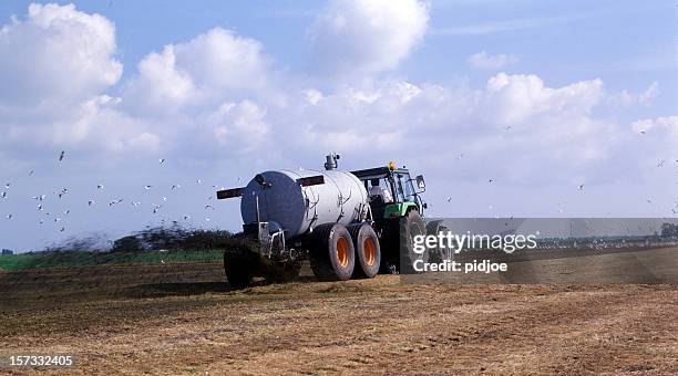 farmer spreading liquid manure - animal dung stock pictures, royalty-free photos & images