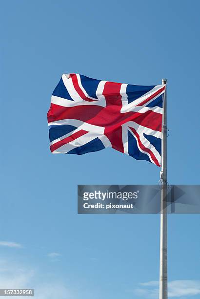 british flag with blue sky in background - english flag stockfoto's en -beelden