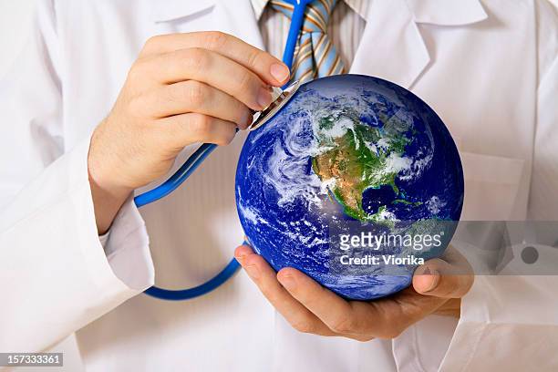 global healthcare - people holding hands around globe stock-fotos und bilder