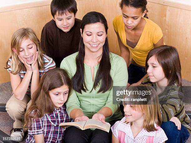 diverse students in a library - paperback stock pictures, royalty-free photos & images