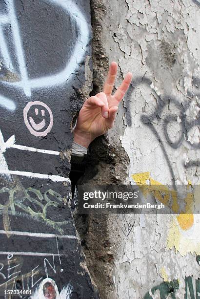 hand, die peace-zeichen in der berliner mauer - mauerfall stock-fotos und bilder