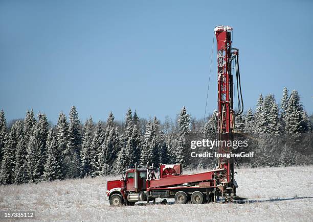red drilling rig in alberta in winter - oil rig alberta stock pictures, royalty-free photos & images
