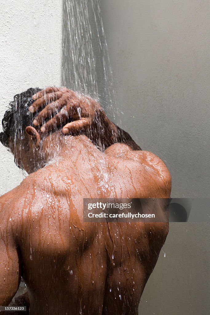 Athletic, tanned  male back under the shower