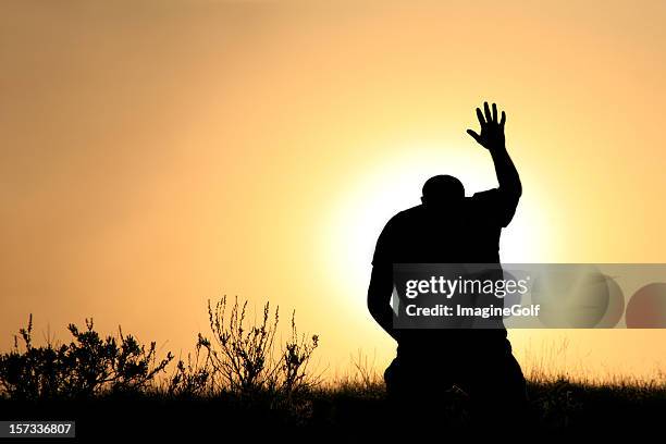 silhouette of man in praise and worship - god is love stock pictures, royalty-free photos & images