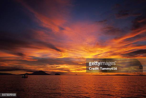 the beautiful warm hues in the sky above a ocean horizon - papua new guinea stock pictures, royalty-free photos & images