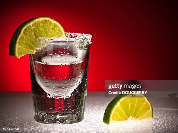 close up of shot glass and limes - shot glass stock pictures, royalty-free photos & images