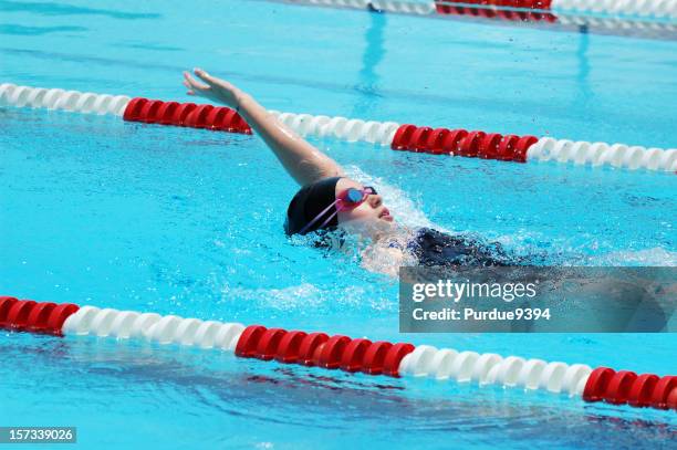 young female backstroke swimmer at swim competition - zwembadlaan scheidingslijn stockfoto's en -beelden