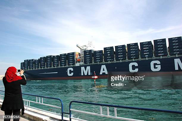 An Egyptian woman takes a photo of the largest and the newest container ship in the world, the British flagged CMA CGM Marco Polo, sails through the...