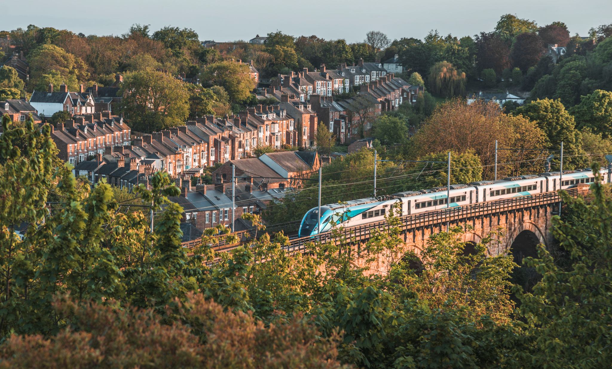 townhouses standing beside the railway on the viaduct with a running train in Durham, UK townhouses standing beside the railway on the viaduct with a running train in Durham, UK