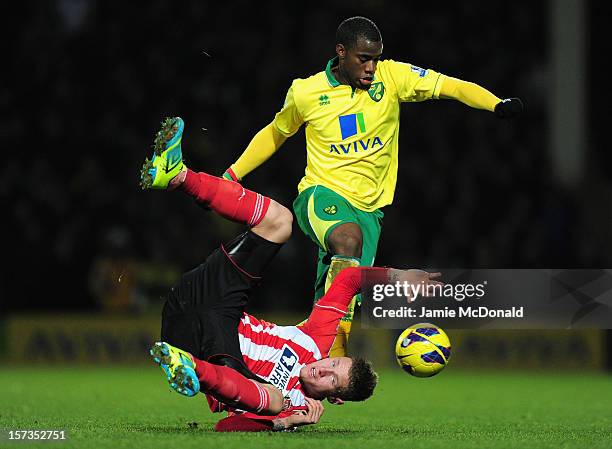 Connor Wickham of Sunderland falls to the pitch under challenge by Sebastien Bassong of Norwich City during the Barclays Premier League match between...
