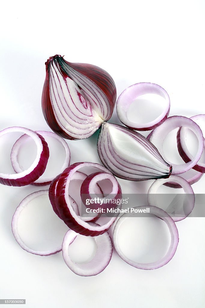 Red onion sliced and sectioned on white background