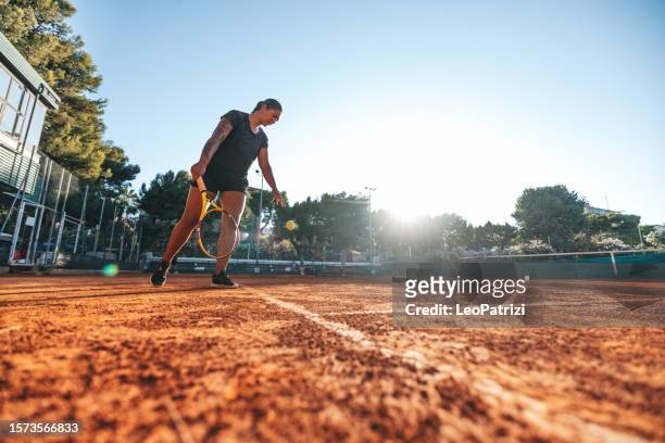 profi-tennisspieler schlägt auf sandplatz auf - tennisturnier stock-fotos und bilder
