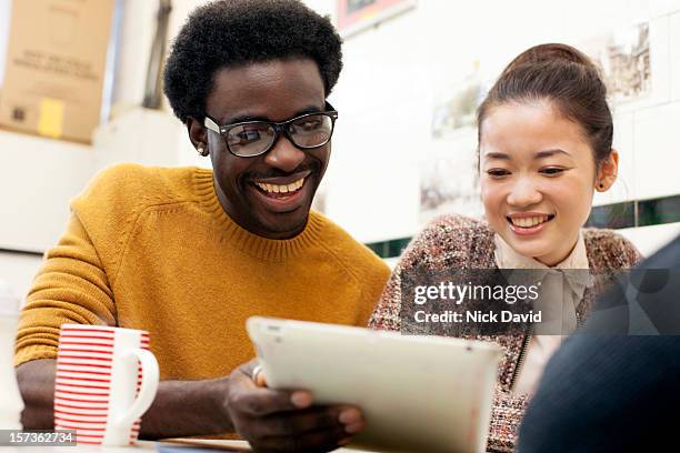 friends at a cafe - holding tablet computer stock pictures, royalty-free photos & images