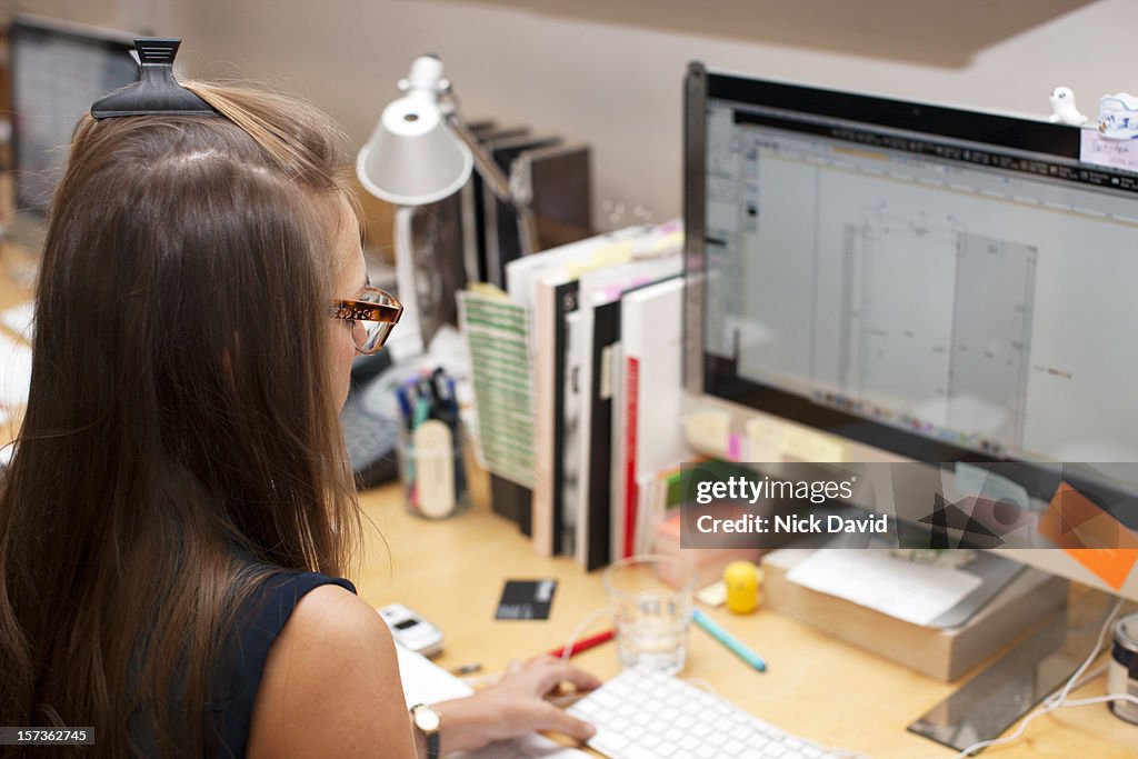 Rear view shot of female office worker looking at her computer