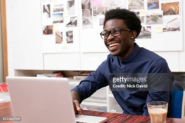 portrait of a confident male business owner smiling off camera - black man laptop foto e immagini stock