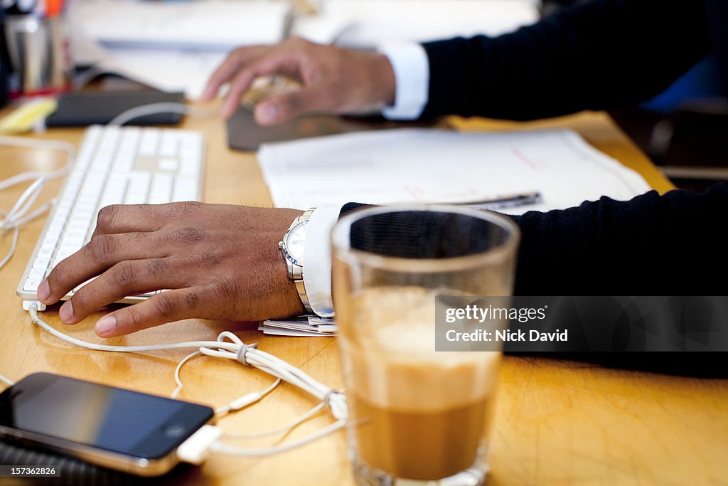 Close up of a man’s hands typing on a computer working in an office