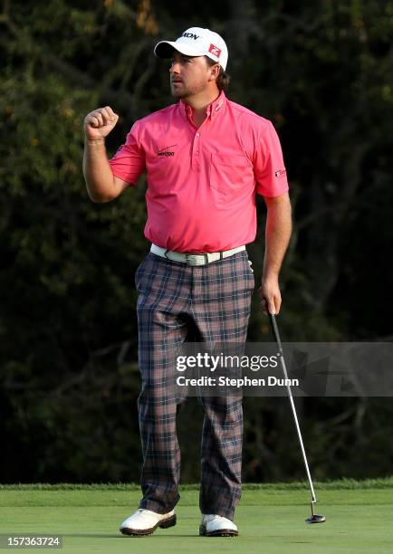 Graeme McDowell of Northern Ireland pumps his fist after making a birdie putt on the 18th hole to cement a three stroke victory during the final...