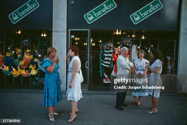 People eating ice creams outside a Benetton in West Berlin, Germany, 1983.