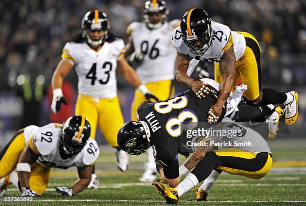 Tight end Dennis Pitta of the Baltimore Ravens is hit by safety Ryan Clark of the Pittsburgh Steelers and other Pittsburgh Steelers defenders in the...