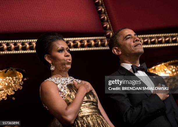 First Lady Michelle Obama and US President Barack Obama listen to the US national anthem during the 2012 Kennedy Center Honors at the Kennedy Center...